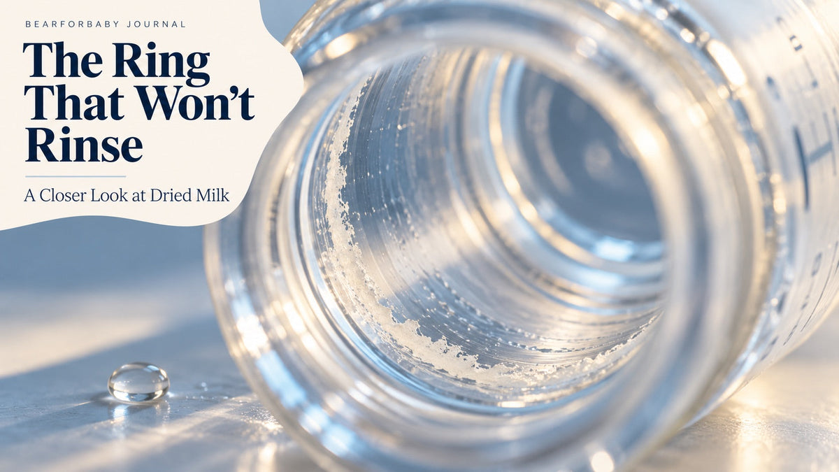A close-up of a faint dried milk ring inside a baby bottle, introducing the challenge of milk-residue cleaning.