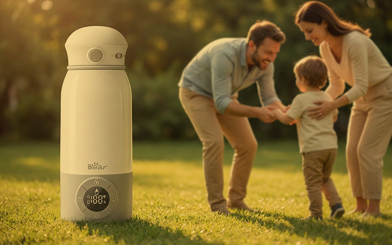 Bear Portable Bottle Warmer on green grass while parents play with their toddler outdoors.