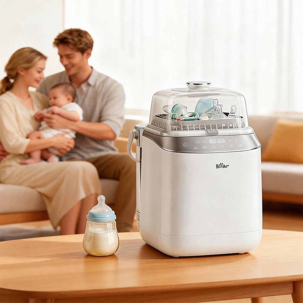 Bear Bottle Washer Pro next to a milk bottle on a wooden table, with parents and baby relaxing on a sofa behind it.