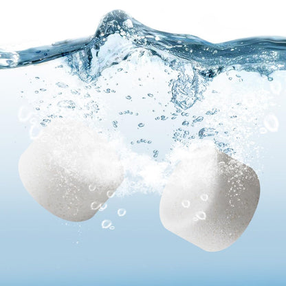 Two white Bear Detergent Tablets rapidly dissolving and effervescing in clean water.