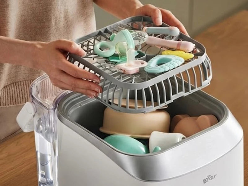 Bear Bottle Washer Pro layered storage design with small baby accessories on the upper rack and larger items below.