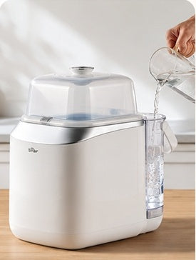 A person pours water into the machine’s water tank.