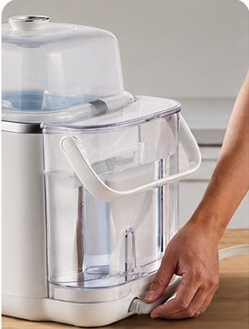 A person connects the drain hose to the outlet at the bottom of the water tank.
